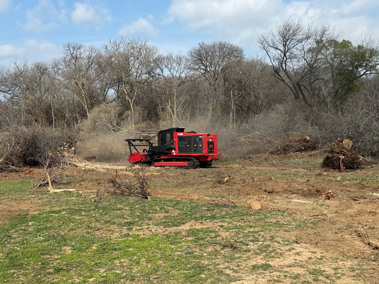 Forestry mulching and brush clearing equipment actively working on a rural property