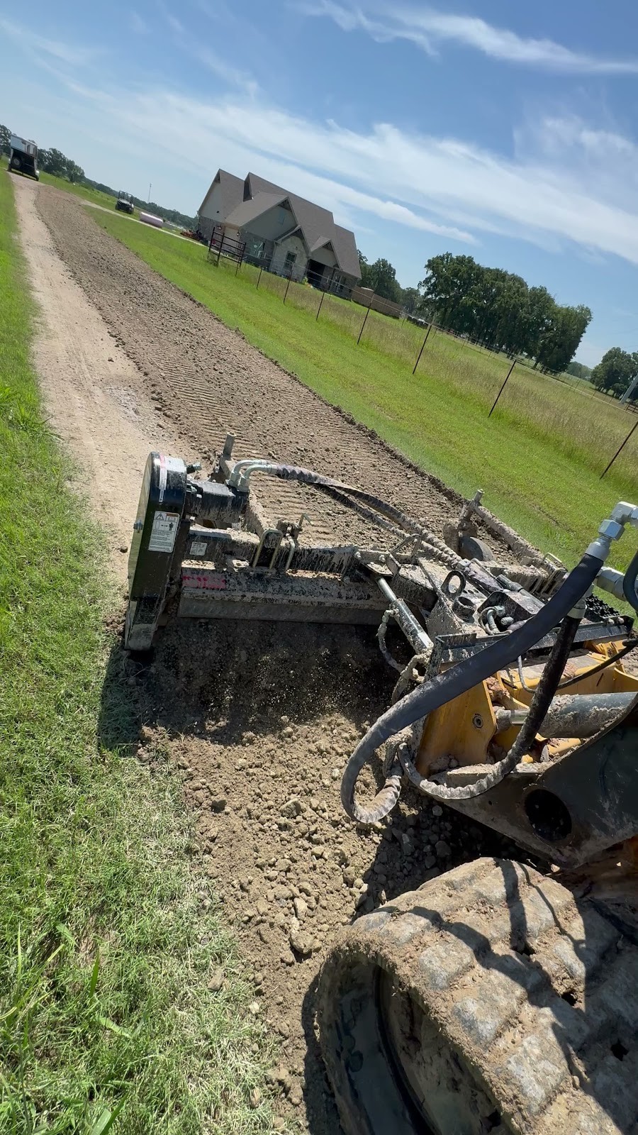 Equipment grading a long rural driveway or access path for dirt work by Your Way Land Clearing LLC